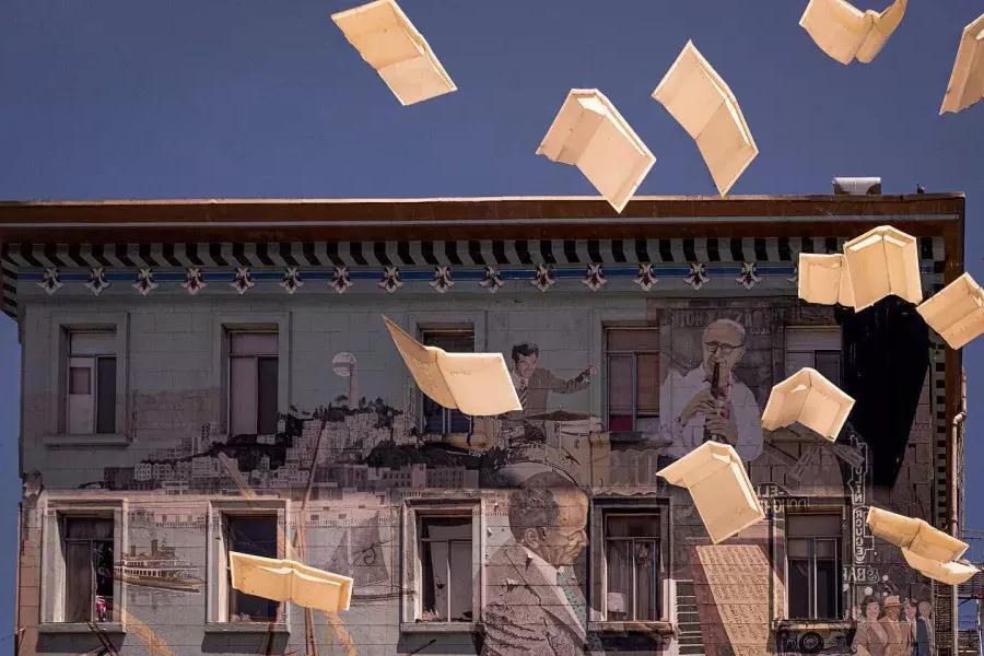 贝博体彩app城市之光书店外的照片，展示一幅墙上的书和浮动纸.